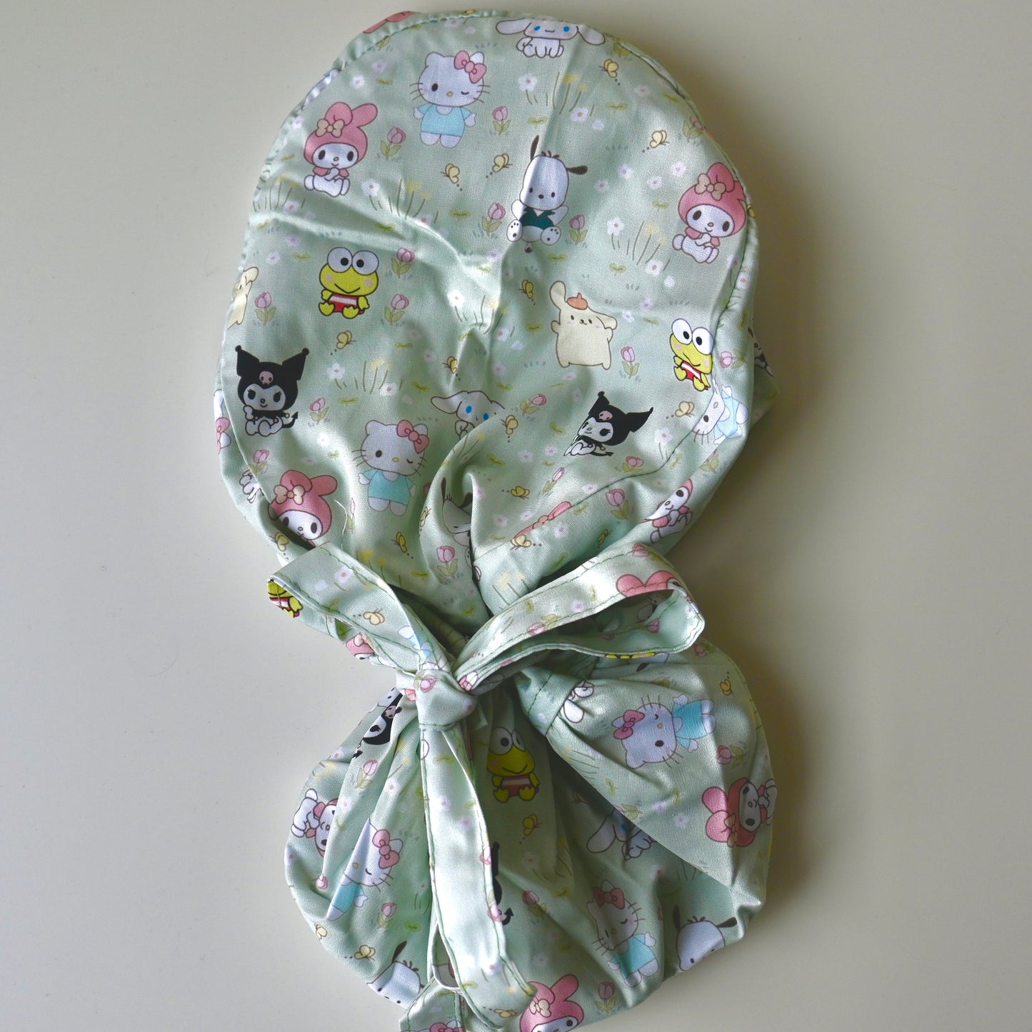 SANRIO CHARACTERS IN GRASS WITH FLOWERS SATIN LINED PONYTAIL SCRUB CAP